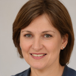 Joyful white adult female with medium  brown hair and grey eyes