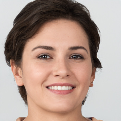 Joyful white young-adult female with short  brown hair and grey eyes