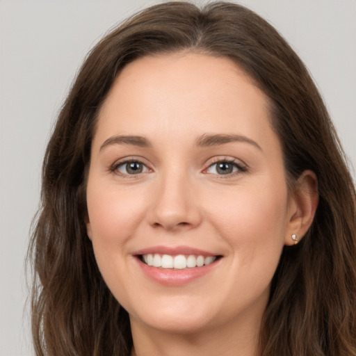 Joyful white young-adult female with long  brown hair and brown eyes