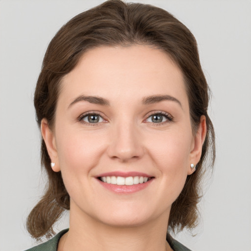 Joyful white young-adult female with medium  brown hair and grey eyes