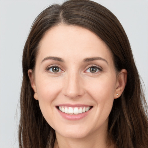 Joyful white young-adult female with long  brown hair and grey eyes