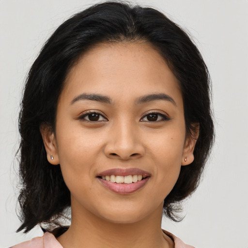 Joyful latino young-adult female with medium  brown hair and brown eyes