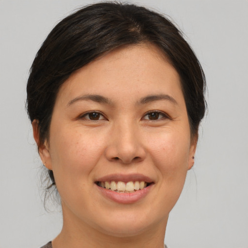 Joyful asian young-adult female with medium  brown hair and brown eyes