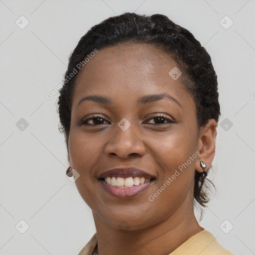 Joyful black young-adult female with short  black hair and brown eyes