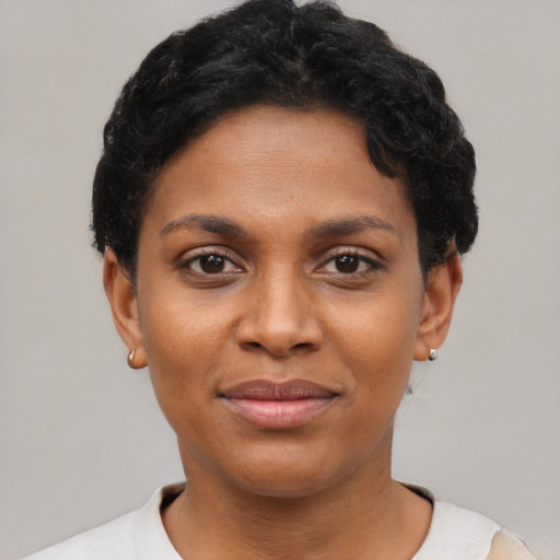 Joyful black young-adult female with short  black hair and brown eyes
