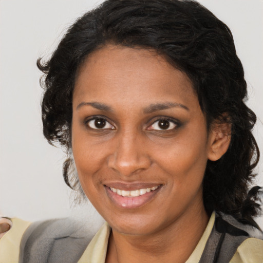 Joyful latino adult female with medium  brown hair and brown eyes