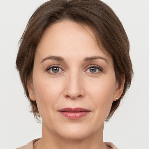 Joyful white adult female with medium  brown hair and grey eyes