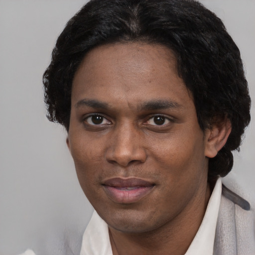 Joyful black adult male with short  black hair and brown eyes