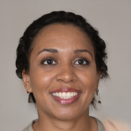 Joyful black adult female with medium  brown hair and brown eyes