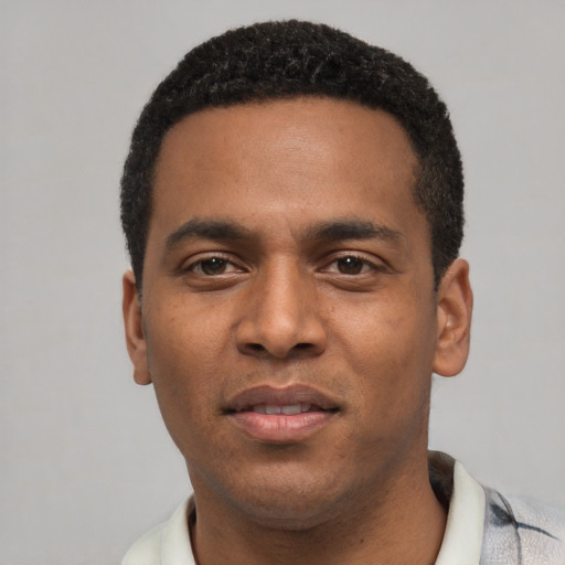Joyful black young-adult male with short  black hair and brown eyes