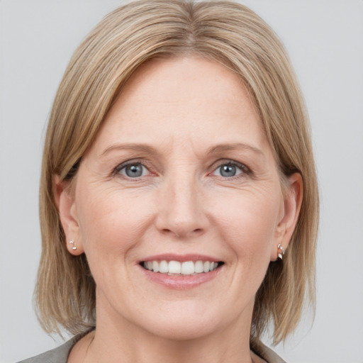 Joyful white adult female with medium  brown hair and grey eyes