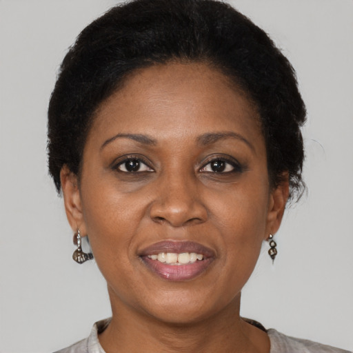 Joyful black adult female with short  black hair and brown eyes