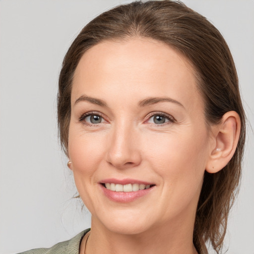 Joyful white young-adult female with medium  brown hair and grey eyes