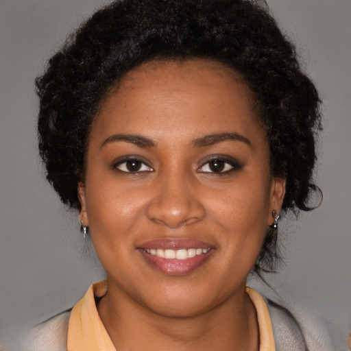 Joyful black young-adult female with long  brown hair and brown eyes