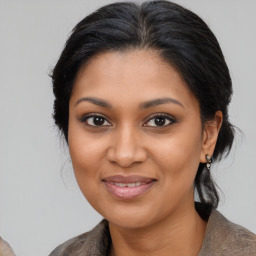 Joyful black young-adult female with medium  brown hair and brown eyes