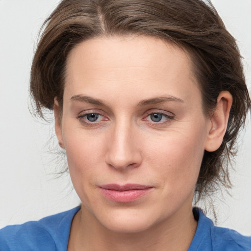 Joyful white young-adult female with medium  brown hair and blue eyes