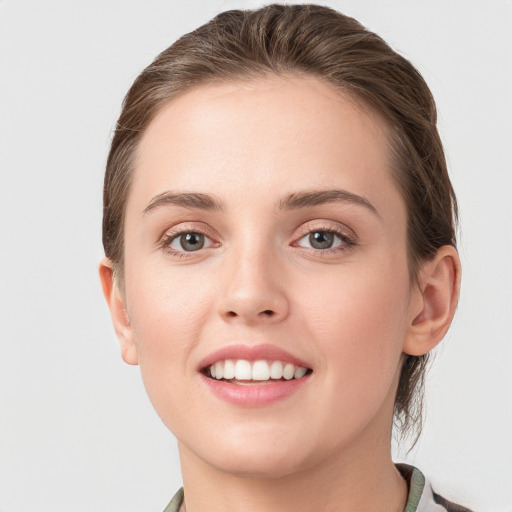 Joyful white young-adult female with medium  brown hair and grey eyes