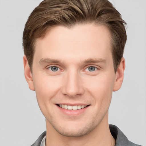 Joyful white young-adult male with short  brown hair and grey eyes