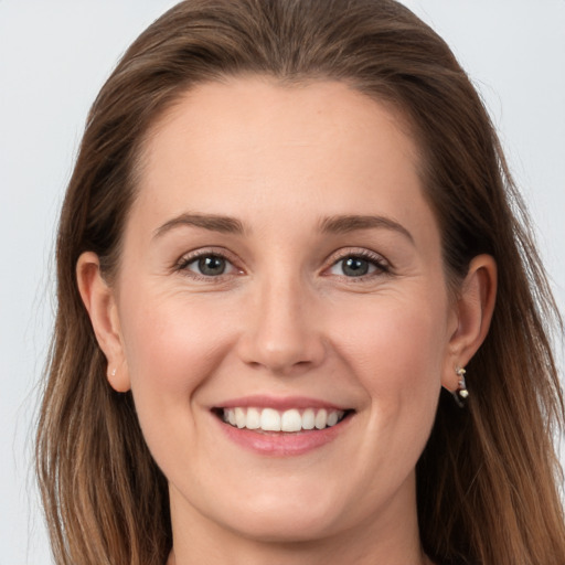 Joyful white young-adult female with long  brown hair and grey eyes