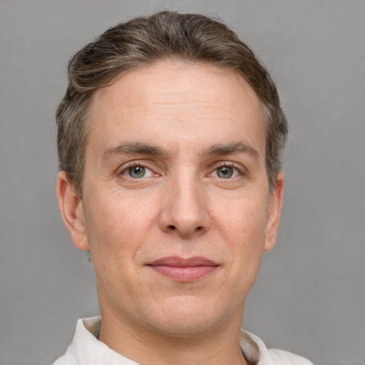 Joyful white adult male with short  brown hair and grey eyes