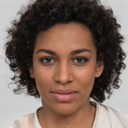 Joyful black young-adult female with medium  brown hair and brown eyes