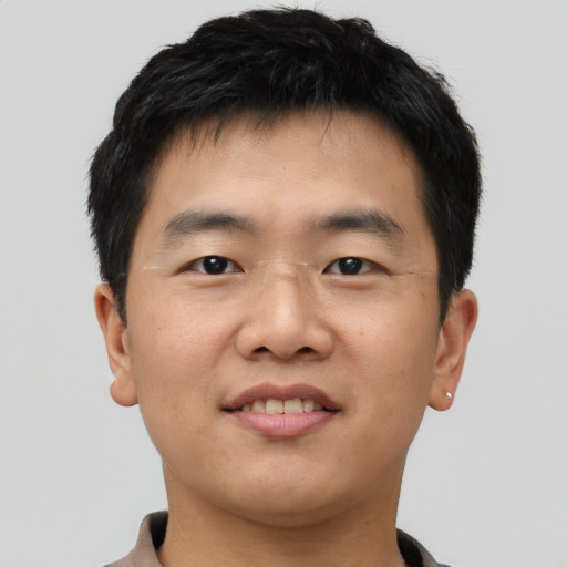Joyful asian young-adult male with short  black hair and brown eyes