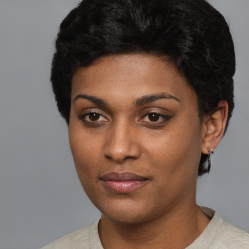 Joyful black young-adult female with short  black hair and brown eyes