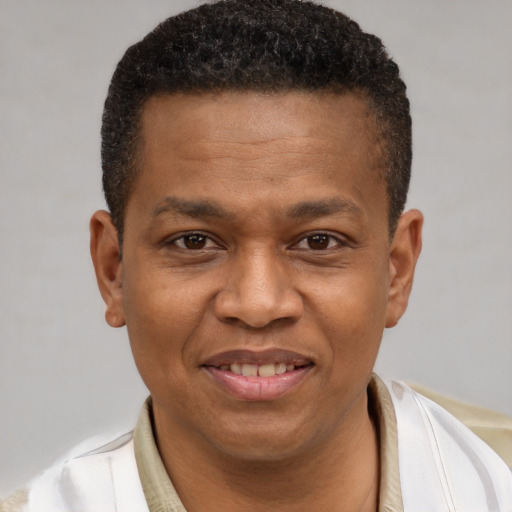 Joyful black young-adult male with short  brown hair and brown eyes