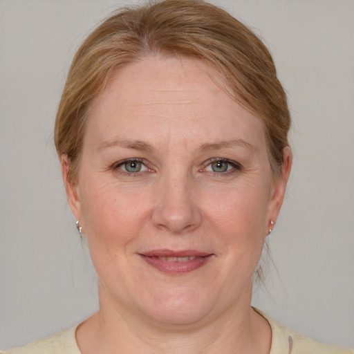 Joyful white adult female with medium  brown hair and blue eyes