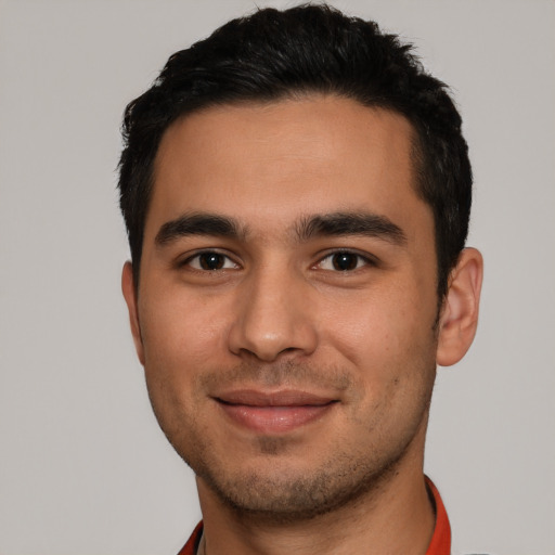 Joyful latino young-adult male with short  black hair and brown eyes