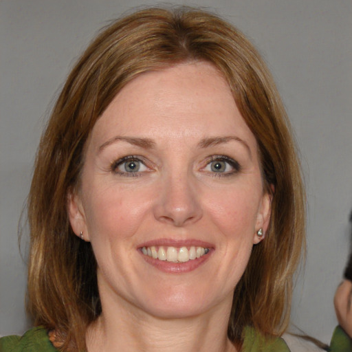 Joyful white adult female with medium  brown hair and brown eyes