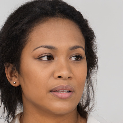 Joyful latino young-adult female with long  brown hair and brown eyes