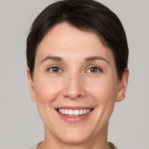 Joyful white young-adult female with short  brown hair and grey eyes