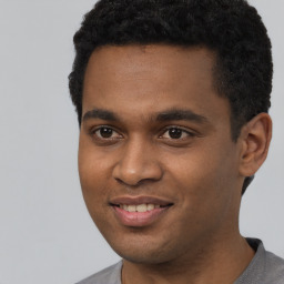 Joyful black young-adult male with short  black hair and brown eyes