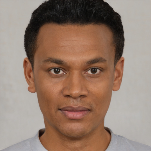 Joyful black young-adult male with short  black hair and brown eyes