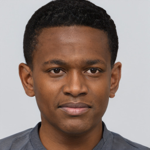 Joyful black young-adult male with short  brown hair and brown eyes