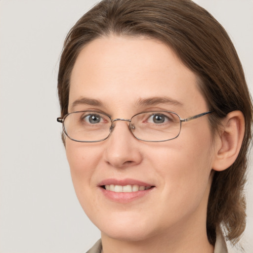 Joyful white adult female with medium  brown hair and grey eyes