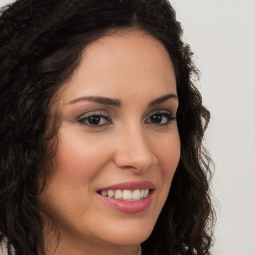 Joyful latino young-adult female with long  brown hair and brown eyes