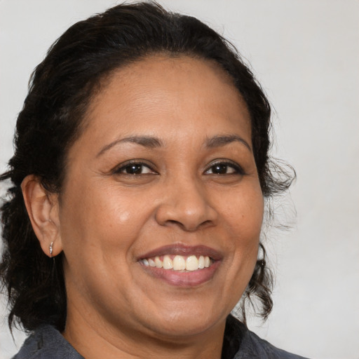Joyful latino adult female with medium  brown hair and brown eyes