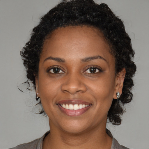Joyful black young-adult female with medium  brown hair and brown eyes