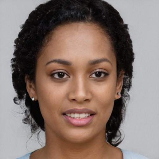 Joyful black young-adult female with long  brown hair and brown eyes