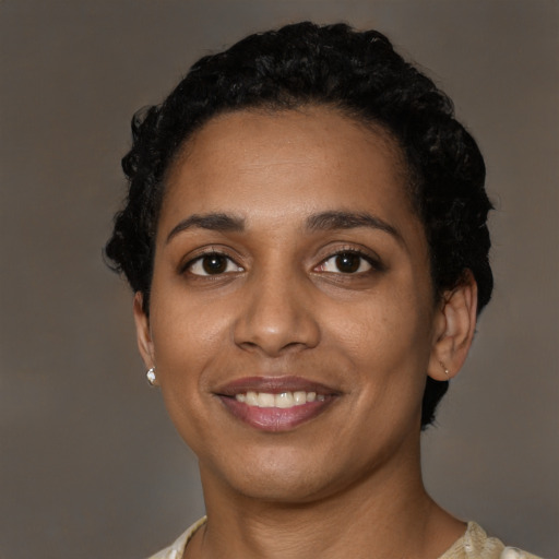 Joyful black young-adult female with short  black hair and brown eyes