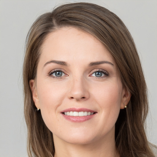 Joyful white young-adult female with long  brown hair and grey eyes