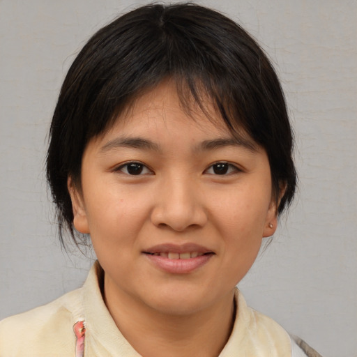 Joyful asian young-adult female with medium  brown hair and brown eyes