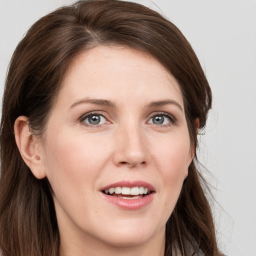 Joyful white young-adult female with long  brown hair and grey eyes