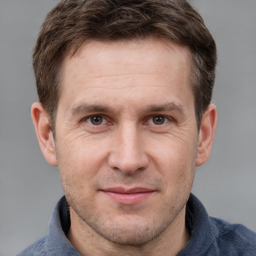 Joyful white adult male with short  brown hair and grey eyes