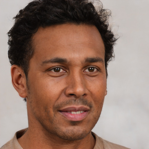 Joyful latino adult male with short  brown hair and brown eyes