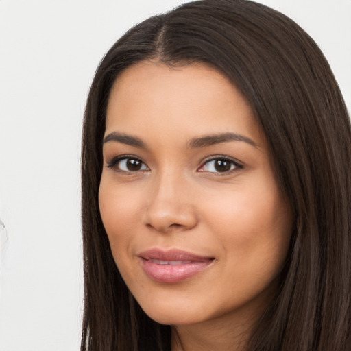 Joyful latino young-adult female with long  brown hair and brown eyes