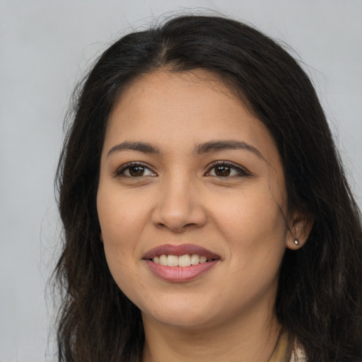 Joyful latino young-adult female with long  brown hair and brown eyes