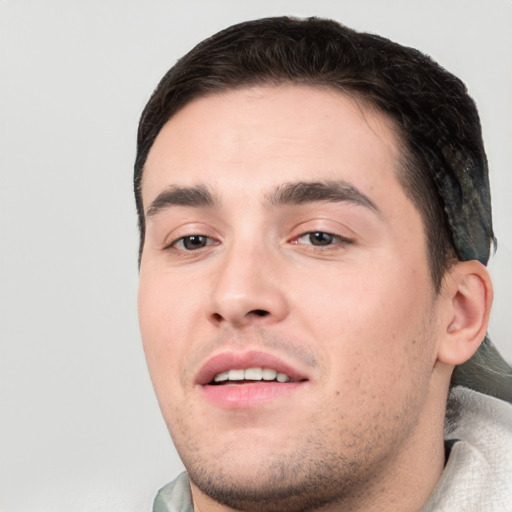 Joyful white young-adult male with short  black hair and brown eyes